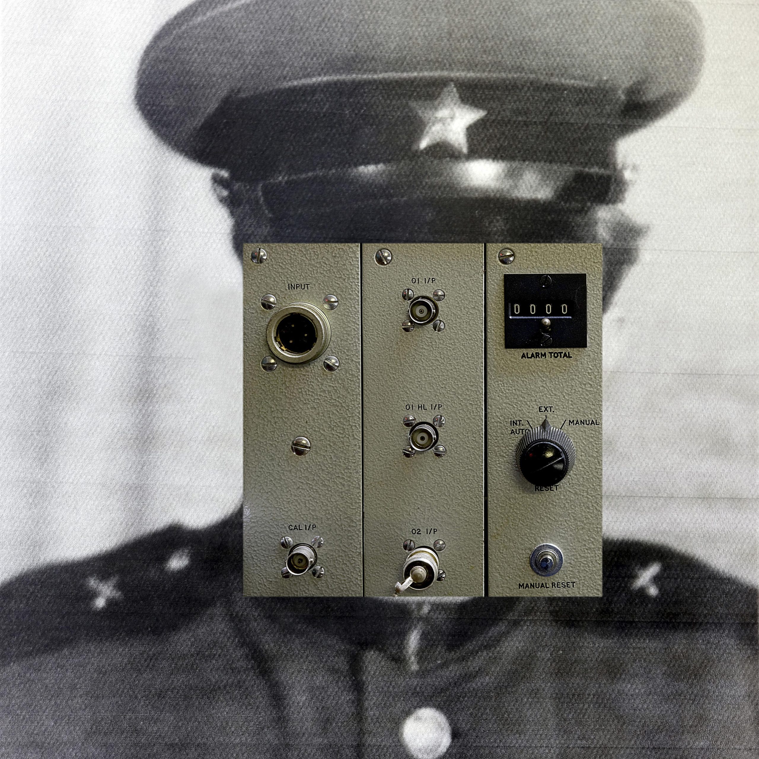 Photograph of a control panel on top of a black and white image of a soldier's head and shoulders